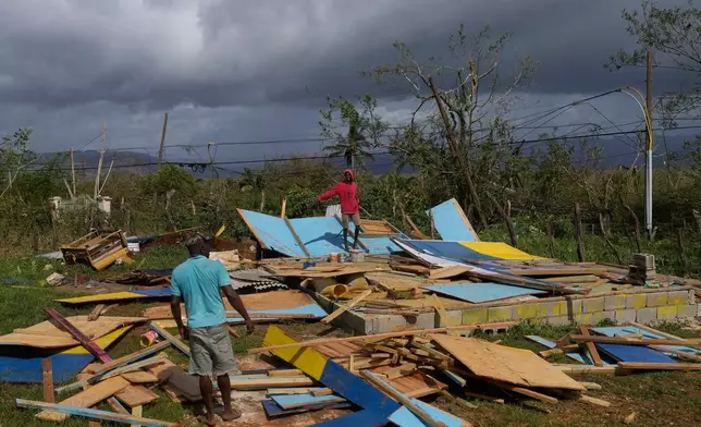 Residents stand on the wreckage of a house destroyed by Hurricane Melissa in Santa Cruz, Jamaica, Wednesday, Oct. 29, 2025. (AP Photo/Matias Delacroix)