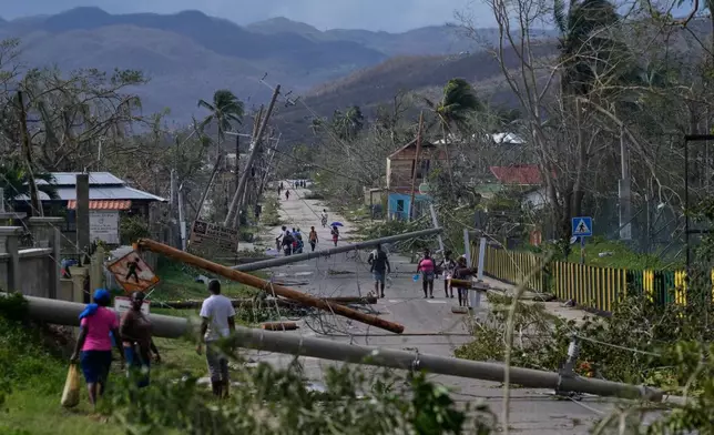 Residents walk through Lacovia Tombstone, Jamaica, in the aftermath of Hurricane Melissa, Wednesday, Oct. 29, 2025. (AP Photo/Matias Delacroix)