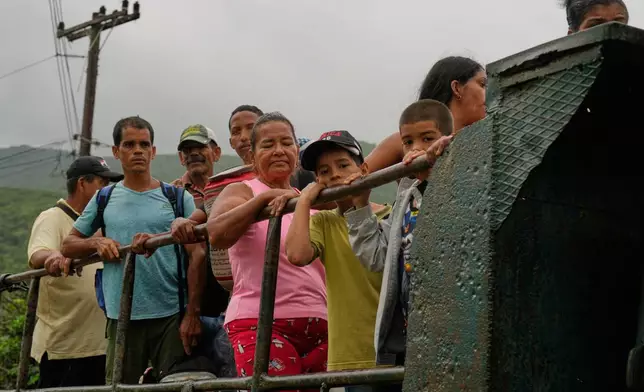 People ride in the back of a truck as they evacuate before the arrival of Hurricane Melissa in Canizo, a community in Santiago de Cuba, Tuesday, Oct. 28, 2025. (AP Photo/Ramón Espinosa)