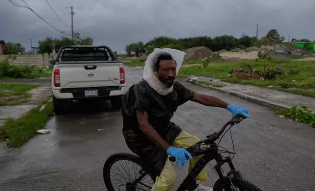 A man rides a bicycle ahead of the forecast arrival of Hurricane Melissa in Kingston, Jamaica, Sunday, Oct. 26, 2025. (AP Photo/Matias Delacroix)