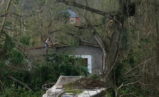A man checks his home's roof after Hurricane Melissa hit Santa Cruz, Jamaica, Wednesday, Oct. 29, 2025. (AP Photo/Matias Delacroix)