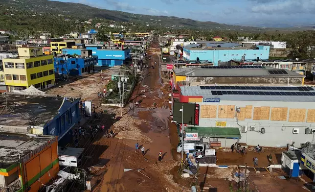 Residents walk through Santa Cruz, Jamaica, Wednesday, Oct. 29, 2025, after Hurricane Melissa passed. (AP Photo/Matias Delacroix),