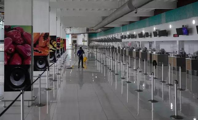 A janitor mops the floor at Norman Manley International Airport, closed ahead of the forecast arrival of Hurricane Melissa, in Kingston, Jamaica, Sunday, Oct. 26, 2025. (AP Photo/Matias Delacroix)