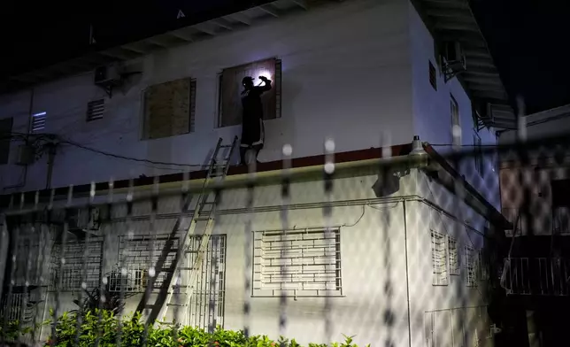 A man boards up a hotel's windows in preparation of Hurricane Melissa's expected arrival in Kingston, Jamaica, Saturday, Oct. 25, 2025. (AP Photo/Matias Delacroix)