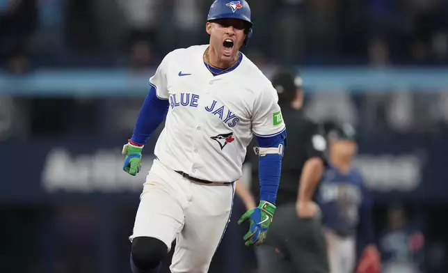 Toronto Blue Jays' George Springer celebrates after hitting a three-run home run against the Seattle Mariners during the seventh inning in Game 7 of baseball's American League Championship Series in Toronto, Monday, Oct. 20, 2025. (Nathan Denette/The Canadian Press via AP)