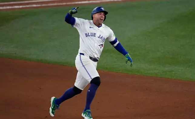Toronto Blue Jays' George Springer celebrates his three run home run against the Seattle Mariners during the seventh inning in Game 7 of baseball's American League Championship Series, Monday, Oct. 20, 2025, in Toronto. (AP Photo/David J. Phillip)