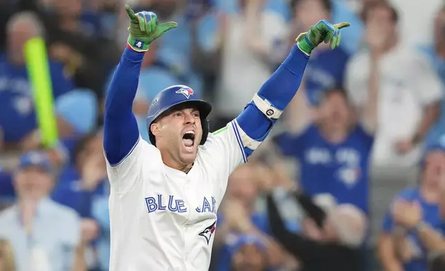 Toronto Blue Jays' George Springer celebrates after hitting a three-run home run against the Seattle Mariners during the seventh inning in Game 7 of baseball's American League Championship Series in Toronto, Monday, Oct. 20, 2025. (Nathan Denette/The Canadian Press via AP)
