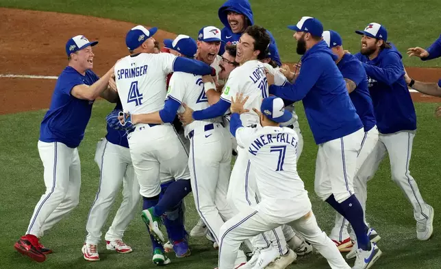 Toronto Blue Jays players celebrate after their Game 7 win over the Seattle Mariners to take baseball's American League Championship Series in Toronto, Monday, Oct. 20, 2025. (Chris Young/The Canadian Press via AP)