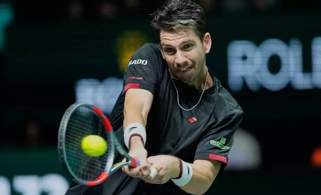 Cameron Norrie of Great Britain returns the ball to Valentin Vacherot of Monaco during their third round men's singles match at the Paris Masters tennis tournament at the Paris La Defense Arena, Thursday, Oct. 30, 2025, in Paris. (AP Photo/Michel Euler)