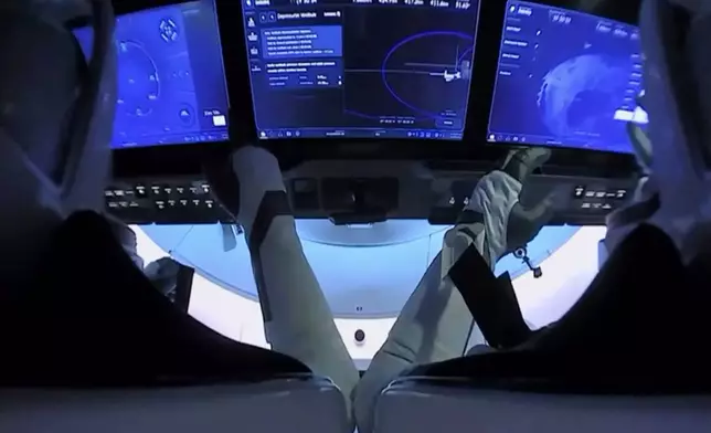 FILE - In this image from video provided by NASA, astronauts Doug Hurley, left, and Bob Behnken prepare for undocking from the International Space Station, aboard the SpaceX Crew Dragon capsule on Saturday, Aug. 1, 2020. (NASA via AP, File)