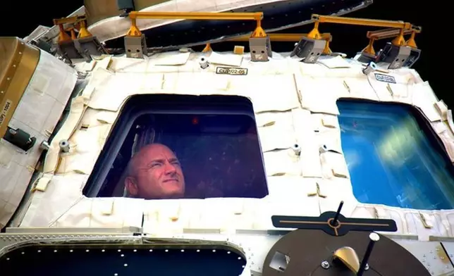 FILE - In this undated photo provided by NASA on Tuesday, March 1, 2016, astronaut Scott Kelly looks out the cupola of the International Space Station. (NASA via AP, File)