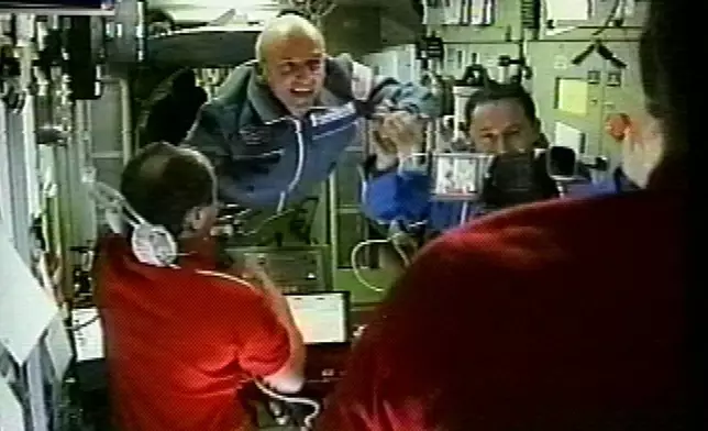FILE - In this image from television, space station commander Yury Usachev, left, welcomes California millionaire Dennis Tito, center, and Russian cosmonauts Talgat Musabayev, right, to the International Space Station on Monday, April 30, 2001. (AP Photo/APTN, File)
