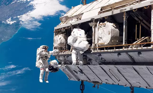 FILE - In this photo provided by NASA, astronaut Robert L. Curbeam Jr., left, and European Space Agency astronaut Christer Fuglesang, participate in a spacewalk during construction of the International Space Station on Dec. 12, 2006. In the background are New Zealand and the Pacific Ocean. (NASA via AP, File)