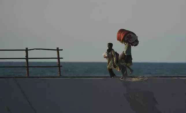 Displaced Palestinians flee northern Gaza carrying their belongings along the coastal road near Wadi Gaza, Thursday, Oct. 2, 2025. (AP Photo/Abdel Kareem Hana)
