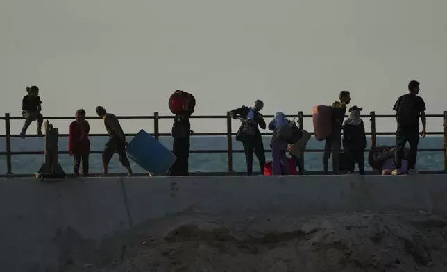 Displaced Palestinians flee northern Gaza carrying their belongings along the coastal road near Wadi Gaza, Thursday, Oct. 2, 2025. (AP Photo/Abdel Kareem Hana)