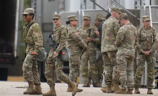 Military personnel in uniform, with the Texas National Guard patch on, are seen at the U.S. Army Reserve Center, Tuesday, Oct. 7, 2025, in Elwood, Ill., a suburb of Chicago. (AP Photo/Erin Hooley)