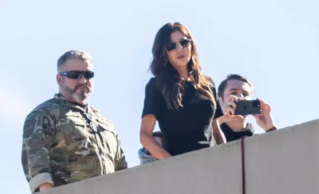 U.S. Secretary of Homeland Security Kristi Noem, center, stands on the roof of a U.S. Immigration and Customs Enforcement facility in Portland, Ore., Tuesday, Oct. 7, 2025. (AP Photo/Ethan Swope)