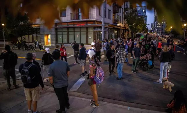 Demonstrators stand outside a U.S. Immigration and Customs Enforcement facility on Tuesday, Oct. 7, 2025, in Portland, Ore. (AP Photo/Ethan Swope)