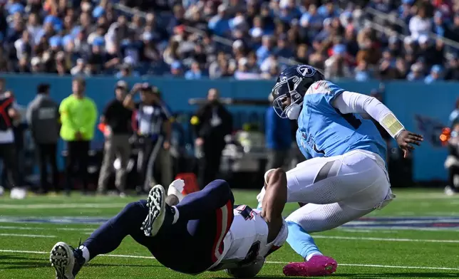 Tennessee Titans quarterback Cam Ward (1) is tackled by New England Patriots linebacker K'Lavon Chaisson (44) during the second half of an NFL football game, Sunday, Oct. 19, 2025, in Nashville, Tenn. (AP Photo/John Amis)