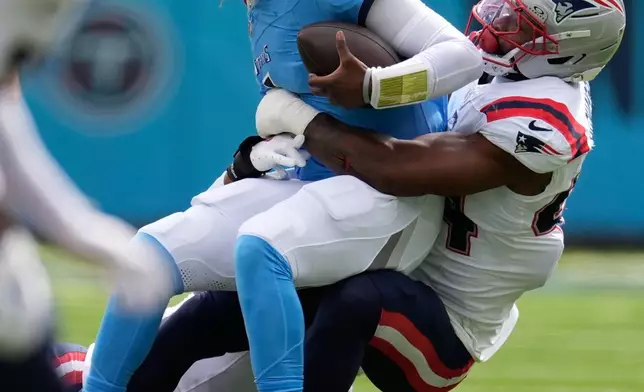 Tennessee Titans quarterback Cam Ward (1) is tackled by New England Patriots linebacker K'Lavon Chaisson (44) during the first half of an NFL football game, Sunday, Oct. 19, 2025, in Nashville, Tenn. (AP Photo/George Walker IV)