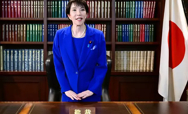 FILE - Sanae Takaichi, the newly-elected leader of Japan's ruling party, the Liberal Democratic Party (LDP), gestures as she leaves the party leader's office after the LDP leadership election in Tokyo Saturday, Oct. 4, 2025. (Yuichi Yamazaki/Pool Photo via AP, File)