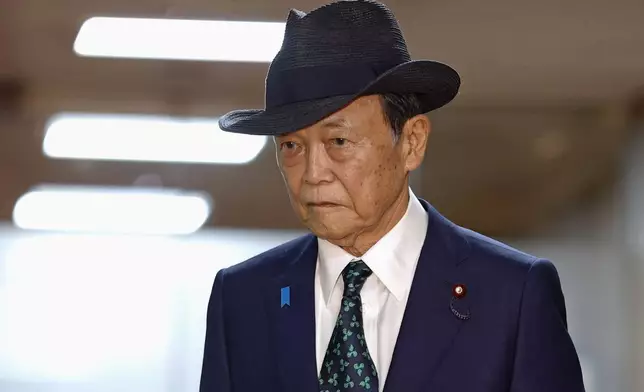 Former Prime Minister Taro Aso walks at the headquarters of the ruling Liberal Democratic Party, after meeting with newly-elected party leader Sanae Takaichi, on Oct. 5, 2025, in Tokyo. (Kyodo News via AP)