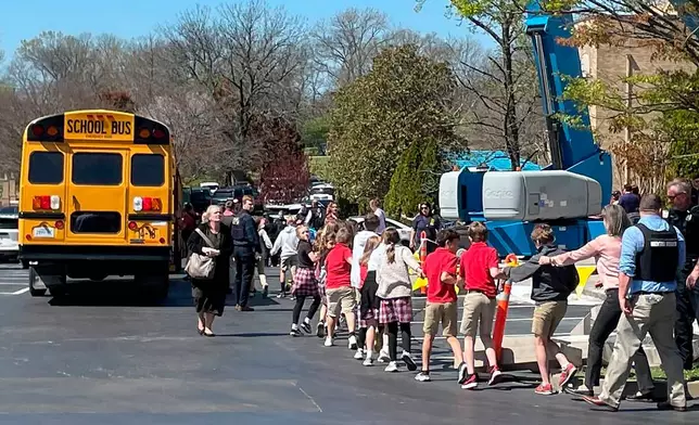 FILE - Children from The Covenant School, a private Christian school in Nashville, Tenn., hold hands as they are taken to a reunification site at the Woodmont Baptist Church after a deadly shooting at their school on March 27, 2023. (AP Photo/Jonathan Mattise, file)