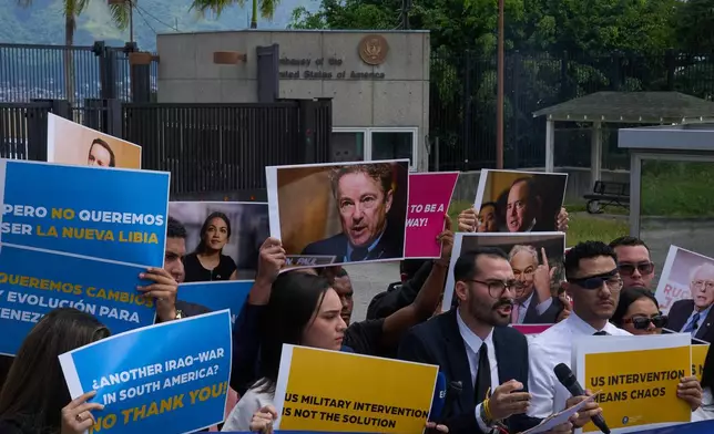 Gabriel Cabrera, president of the Venezuelan Youth Center for Democracy, gives a statement outside of the U.S. embassy with members of the organization holding signs against U.S. intervention, in reference to U.S. warships operating in the Caribbean, in Caracas, Venezuela, Monday, Oct. 27, 2025. (AP Photo/Ariana Cubillos)