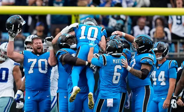 Carolina Panthers kicker Ryan Fitzgerald (10) is lifted by teammates after Fitzgerald kicked a game-winning field goal against the Dallas Cowboys in an NFL football game, Sunday, Oct. 12, 2025, in Charlotte, N.C. (AP Photo/Erik Verduzco)