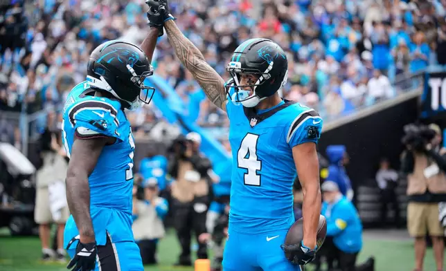 Carolina Panthers' Xavier Legette, left, and Tetairoa McMillan (4) celebrates after McMillan caught a touchdown pass in the first half of an NFL football game against the Dallas Cowboys Sunday, Oct. 12, 2025, in Charlotte, N.C. (AP Photo/Jacob Kupferman)