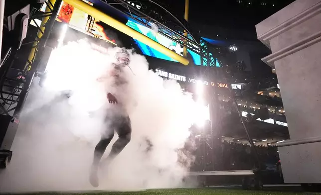 New Orleans Saints tight end Taysom Hill runs onto the field before an NFL football game against the New England Patriots, Sunday, Oct. 12, 2025, in New Orleans. (AP Photo/Gerald Herbert)