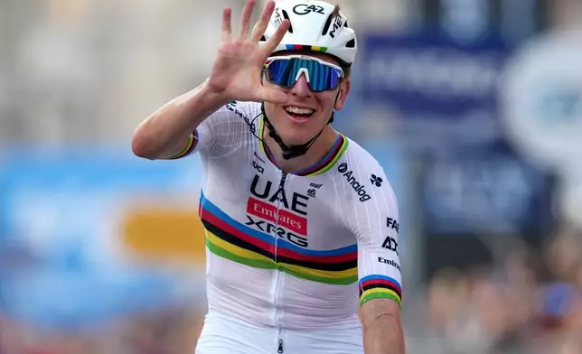 Reigning World Champion Tadej Pogacar indicates five as he celebrates winning his fifth in a row Il Lombardia, Tour of Lombardy cycling race, in Bergamo, Italy, Saturday, Oct. 11, 2025. (Gian Mattia D'Alberto/LaPresse via AP)