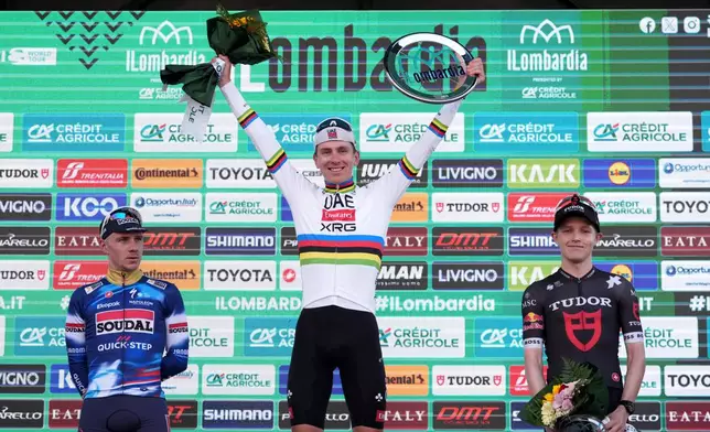 Reigning World Champion Tadej Pogacar of Slovenia, center, winner of Il Lombardia, Tour of Lombardy cycling race, celebrates on podium with second placed Belgium's Remco Evenepoel, left, and third placed Australia's Michael Storer, in Bergamo, Italy, Saturday, Oct. 11, 2025. (Gian Mattia D'Alberto /LaPresse via AP)