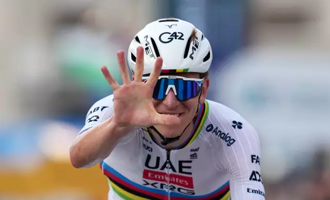 Reigning World Champion Tadej Pogacar indicates five as he celebrates winning his fifth in a row Il Lombardia, Tour of Lombardy cycling race, in Bergamo, Italy, Saturday, Oct. 11, 2025. (Gian Mattia D'Alberto/LaPresse via AP)