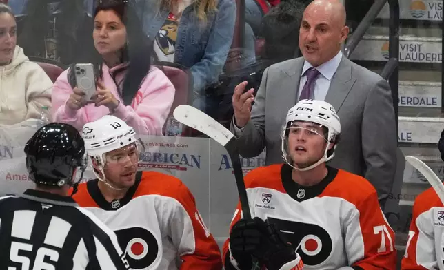 Philadelphia Flyers head coach Rick Tocchet gestures to referee Matt McPherson (56) during the first period of an NHL hockey game against the Florida Panthers, Thursday, Oct. 9, 2025, in Sunrise, Fla. (AP Photo/Marta Lavandier)