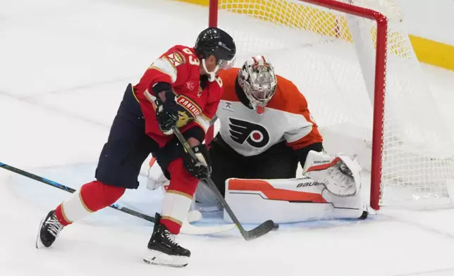 Philadelphia Flyers goaltender Dan Vladar (80) stops a shot by Florida Panthers left wing Brad Marchand (63) during the second period of an NHL hockey game, Thursday, Oct. 9, 2025, in Sunrise, Fla. (AP Photo/Marta Lavandier)
