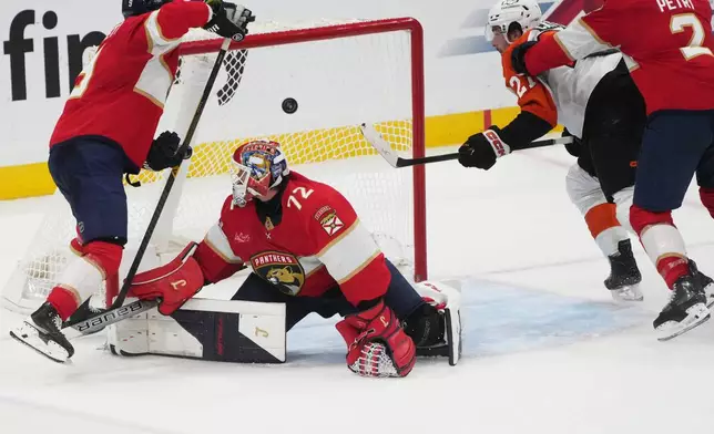 Philadelphia Flyers left wing Noah Cates (27), right, scores a goal against Florida Panthers goaltender Sergei Bobrovsky (72) during the second period of an NHL hockey game, Thursday, Oct. 9, 2025, in Sunrise, Fla. (AP Photo/Marta Lavandier)