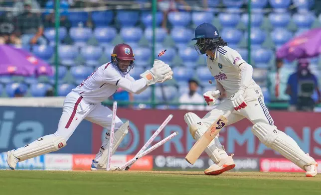 West Indies' wicketkeeper Tevin Imlach takes the bails off of India's KL Rahul, right, on the first day of the second cricket test match between India and West Indies at the Arun Jaitley Stadium in New Delhi, India, Friday, Oct.10, 2025. (AP Photo/Manish Swarup)