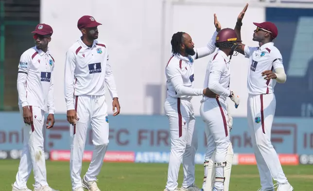 West Indies' Jomel Warrican, center, celebrates the dismissal of India's KL Rahul with teammates on the first day of the second cricket test match between India and West Indies at the Arun Jaitley Stadium in New Delhi, India, Friday, Oct.10, 2025. (AP Photo/Manish Swarup)