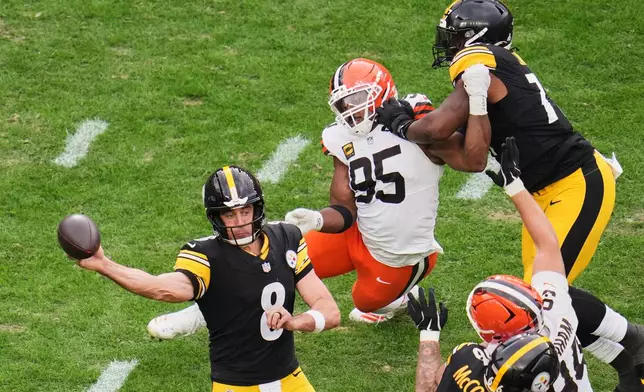 Pittsburgh Steelers quarterback Aaron Rodgers (8) passes under pressure from Cleveland Browns defensive end Myles Garrett (95) in the second half of an NFL football game in Pittsburgh, Sunday, Oct. 12, 2025. (AP Photo/Gene J. Puskar)