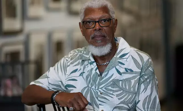 Joe Calhoun poses in front of historical photos of the National Guard during the 1968 sanitation strike, Monday, Sept. 29, 2025, in Memphis, Tenn. (AP Photo/George Walker IV)