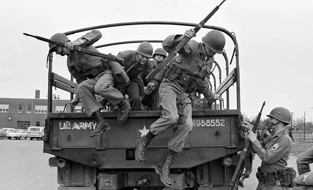 FILE - Tennessee National Guard troops leap out of a truck at the Memphis Armory after being ordered into the city by Gov. Buford Ellington at the request of city officials, March 28, 1968, in Memphis, Tenn. The guard was ordered after rioting and looting erupted midway through a march led by Dr. Martin Luther King Jr. in support of striking garbage workers. (AP Photo/Jack Thornell, File)