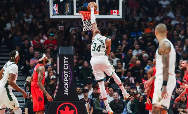 Milwaukee Bucks' Giannis Antetokounmpo (34) dunks on the Toronto Raptors net during first half NBA basketball action in Toronto on Friday, Oct. 24, 2025. (Nick Iwanyshyn/The Canadian Press via AP)