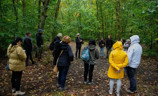 Wolfgang Bivour 75, center, a mushroom hunting tour leader, instructs mushroom pickers on how to hunt mushrooms in a forest in Potsdam, Germany, Wednesday, Oct. 8, 2025. (AP Photo/Ebrahim Noroozi)
