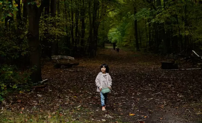 Angela Zhu 5, who is on a mushroom hunting trip with her parents, searches for mushrooms in a forest in Potsdam, Germany, Wednesday, Oct. 8, 2025. (AP Photo/Ebrahim Noroozi)