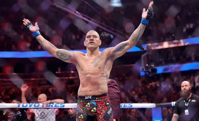 Alex Pereira, of Brazil, celebrates after defeating UFC light heavyweight champion Magomed Ankalaev, of Russia during the UFC 320 mixed martial arts bout Saturday, Oct. 4, 2025, in Las Vegas. (Steve Marcus/Las Vegas Sun via AP)