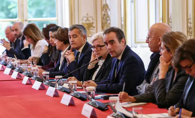 France's reappointed Prime Minister Sebastien Lecornu, fourth right, delivers a speech next to France's Defense Catherine Vautrin, fifth right, and Justice Minister Gerald Darmanin, sixth right, as he welcomes the newly-appointed members of his cabinet in Paris, Monday, Oct. 13, 2025. (Alain Jocard, Pool photo via AP)