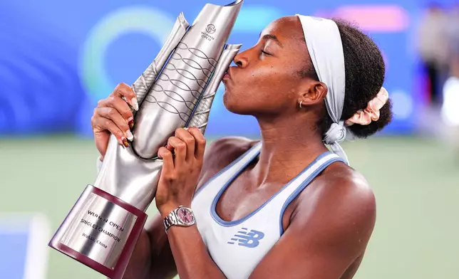 Coco Gauff of the United States celebrates with her trophy after defeating her compatriot Jessica Pegula in the women's singles final at the WTA Wuhan Open in Wuhan in central China's Hubei province Sunday, Oct. 12, 2025. (Chinatopix Via AP) CHINA OUT