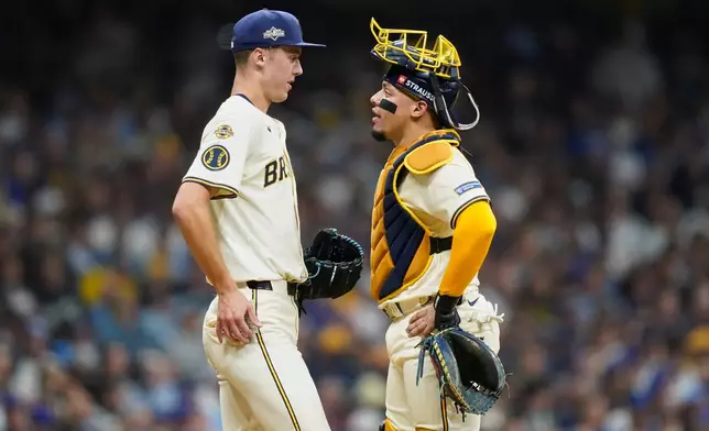 Milwaukee Brewers relief pitcher Jacob Misiorowski (32) and catcher William Contreras (24) talk during the fourth inning of Game 2 of baseball's National League Division Series against the Chicago Cubs Monday, Oct. 6, 2025, in Milwaukee. (AP Photo/Kayla Wolf)
