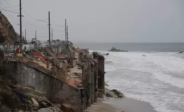 Beachfront properties damages by the Palisades Fire are shown during a storm on Tuesday, Oct. 14, 2025, in Malibu, Calif. (AP Photo/Ethan Swope)